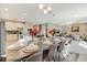 Open dining room with a large table, modern lighting, and access to the kitchen and living room at 4418 Shiva Loop, Kissimmee, FL 34746