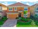 Charming two-story home with a terracotta roof, attached garage, and well-manicured landscaping at 4418 Shiva Loop, Kissimmee, FL 34746