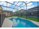 Inviting in-ground pool and backyard featuring a covered patio and surrounding greenery at 4418 Shiva Loop, Kissimmee, FL 34746