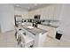 Modern kitchen with white cabinets, granite countertops, stainless steel appliances and an island with barstool seating at 4420 Shiva Loop, Kissimmee, FL 34746