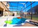 Inviting screened-in pool area features a clear blue pool, patio seating and a built-in grill for outdoor entertaining at 4420 Shiva Loop, Kissimmee, FL 34746
