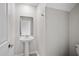 Powder room with pedestal sink, decorative mirror, brushed nickel hardware, and neutral flooring at 4423 Blackbird St, Kissimmee, FL 34746