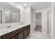 Bright bathroom featuring a dual sink vanity and a glass-enclosed shower at 4423 Blackbird St, Kissimmee, FL 34746