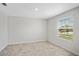 Bright bedroom with neutral tile floors, white walls, and a large window overlooking the front yard at 4423 Blackbird St, Kissimmee, FL 34746