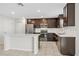 Spacious kitchen with stainless steel appliances, dark wood cabinets, and a white countertop kitchen island at 4423 Blackbird St, Kissimmee, FL 34746