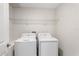 Neat laundry area featuring a full-size washer and dryer, complemented by overhead shelving at 4423 Blackbird St, Kissimmee, FL 34746