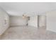 Spacious living room with neutral tile floors, a decorative ceiling fan, white walls, and access to the staircase at 4423 Blackbird St, Kissimmee, FL 34746