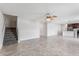 Open-concept living room featuring tile flooring, a ceiling fan, and stairway access to the second floor at 4423 Blackbird St, Kissimmee, FL 34746