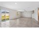 Large living room featuring neutral tile floors, white walls, and a sliding glass door to the backyard at 4423 Blackbird St, Kissimmee, FL 34746
