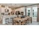 Open-concept kitchen and dining area featuring white cabinets, stainless steel appliances, and a large wooden dining table at 5235 Bowspirit Way, St Cloud, FL 34771