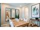 A modern dining room boasts a spacious wood table, comfortable seating, elegant mirrors, and stylish decor at 5241 Quillback Ln, St Cloud, FL 34771
