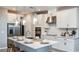 A modern kitchen shines with white cabinets, stainless appliances, a stylish island, and elegant pendant lighting at 5241 Quillback Ln, St Cloud, FL 34771