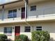 Close-up view of a two-story complex featuring blue railings and neatly trimmed bushes at 5505 Hernandes Dr # 118, Orlando, FL 32808