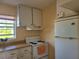 The kitchen features a white fridge and stove with a window for natural light at 5505 Hernandes Dr # 118, Orlando, FL 32808