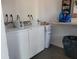 Clean laundry room with multiple machines, a shelf, and a trash can at 5505 Hernandes Dr # 118, Orlando, FL 32808
