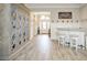 Elegant bar area with a custom cabinet, lighting, and wood-look tile flooring, perfect for entertaining guests at 5896 Barclay Ct, The Villages, FL 32163