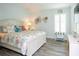 Cozy bedroom with white furniture, coastal decor, wood floors, and natural light at 5896 Barclay Ct, The Villages, FL 32163