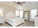Well-lit bedroom features a ceiling fan, hardwood floors, and beach-themed decor at 5896 Barclay Ct, The Villages, FL 32163