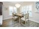 Dining room with a neutral color palette, wood floors, and an elegant chandelier, perfect for entertaining at 5896 Barclay Ct, The Villages, FL 32163