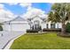 Charming single-story home with well-maintained lawn, lush landscaping, and a pristine three-car garage at 5896 Barclay Ct, The Villages, FL 32163