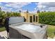 Inviting backyard hot tub with privacy screen, set against a backdrop of lush greenery and blue skies at 5896 Barclay Ct, The Villages, FL 32163