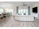 Open living room with white furniture, wood floors, and relaxing coastal decor at 5896 Barclay Ct, The Villages, FL 32163