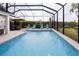 A luxurious pool with water features, surrounded by lounge chairs and a dining area for entertaining at 5896 Barclay Ct, The Villages, FL 32163
