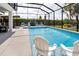 Screened-in pool has fountains, patio furniture, and a lush landscaped yard at 5896 Barclay Ct, The Villages, FL 32163