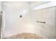 Modern shower with marble-style tiling, pebble flooring, a built-in corner seat and grab bar at 5896 Barclay Ct, The Villages, FL 32163