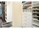 White walk-in closet has custom shelving and drawers for organized storage at 5896 Barclay Ct, The Villages, FL 32163