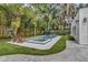 Garage and pool with spa in a landscaped backyard surrounded by tropical plants and trees at 613 Daniels Ave, Orlando, FL 32801