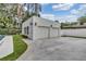 Two-car garage with adjacent pool in a landscaped backyard surrounded by tropical plants and trees at 613 Daniels Ave, Orlando, FL 32801