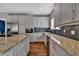 Modern kitchen with granite counters, hardwood floors, stainless appliances, and bright cabinets at 613 Daniels Ave, Orlando, FL 32801