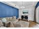Comfortable living room with blue accent wall, recessed cabinets, TV, wood floors and neutral furniture at 613 Daniels Ave, Orlando, FL 32801