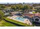 Aerial view showcasing a pool area with a clubhouse, tennis courts, playground, and ample seating at 6301 Parson Brown Dr, Orlando, FL 32819