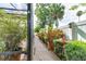 Manicured backyard path featuring beautiful plants and shrubs lining the paver pathway, creating a tranquil garden space at 677 Cheoy Lee Cir, Winter Springs, FL 32708