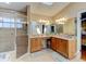 Bathroom boasts dual sinks, wooden cabinets, granite counters and a glass enclosed shower at 677 Cheoy Lee Cir, Winter Springs, FL 32708