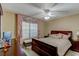 Cozy bedroom with a ceiling fan, carpet, and a large window letting in plenty of natural light at 677 Cheoy Lee Cir, Winter Springs, FL 32708