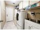 Laundry room with a sink, shelving, cabinets, tile floors, and modern washer and dryer units at 677 Cheoy Lee Cir, Winter Springs, FL 32708