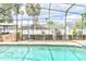 Private screened-in pool area with a brick outdoor kitchen and lush landscaping at 677 Cheoy Lee Cir, Winter Springs, FL 32708