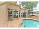 Outdoor pool area with brick pavers, covered seating, and an outdoor kitchen area at 677 Cheoy Lee Cir, Winter Springs, FL 32708