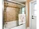 Bathroom shower and tub combination behind glass doors with a shower head and white door nearby at 677 Cheoy Lee Cir, Winter Springs, FL 32708