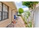 Property side yard features brick pavers, tropical landscaping, and direct access to the home's utilities at 677 Cheoy Lee Cir, Winter Springs, FL 32708