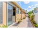Paver walkway lined with plants and white fence leading to the sliding glass door and backyard at 677 Cheoy Lee Cir, Winter Springs, FL 32708