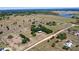 An aerial view highlights treed areas, fenced areas, and water on this large property at 7823 Baron Ave, Howey In The Hills, FL 34737