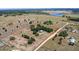 Aerial view of property with red boundary line near a calm lake and open fields at 7823 Baron Ave, Howey In The Hills, FL 34737