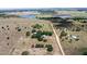 An aerial view showing the vast acreage with two homes, a lake, and treed areas at 7823 Baron Ave, Howey In The Hills, FL 34737