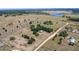 The expansive acreage includes treed areas, a lake, and fenced areas, as shown in an aerial view at 7823 Baron Ave, Howey In The Hills, FL 34737