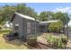 Backyard showing sheds, garden boxes, and green space surrounded by trees at 7823 Baron Ave, Howey In The Hills, FL 34737