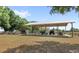 Open carport featuring a boat, ATV, and lawnmower for property maintenance and leisure at 7823 Baron Ave, Howey In The Hills, FL 34737